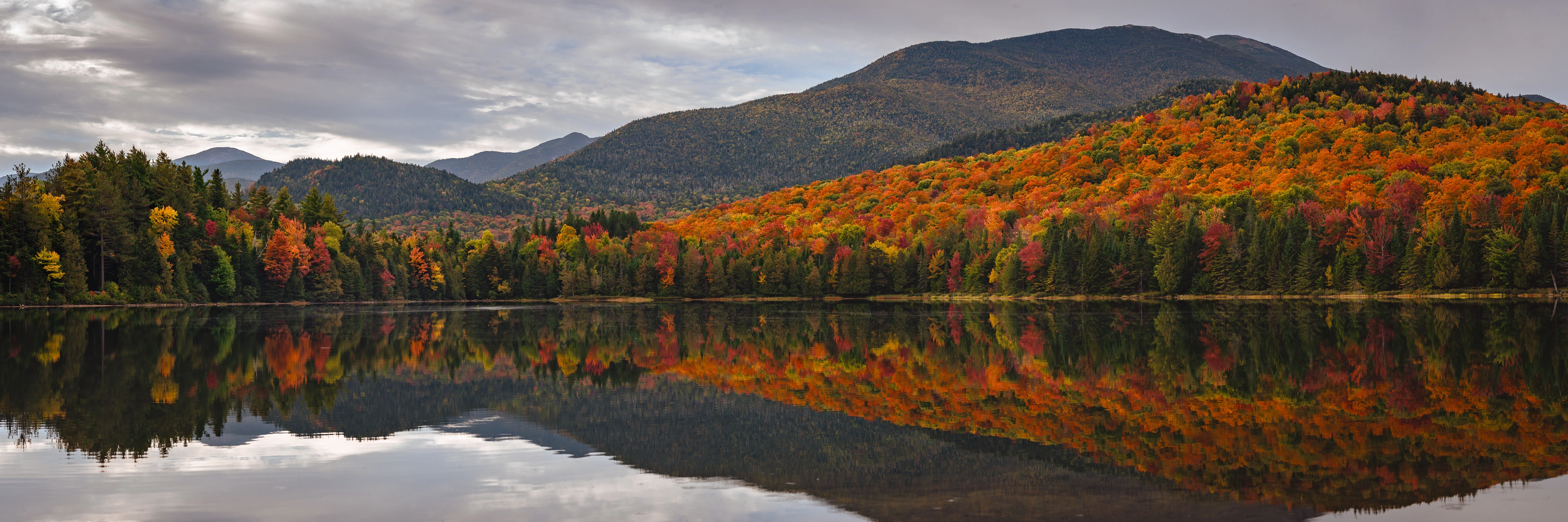 A still morning at Heart Lake holds the MacIntyre Range on the right, Colden's northeast summit near the center, and Mount Marcy to the left. Heart Lake, Adirondack High Peaks, New York.