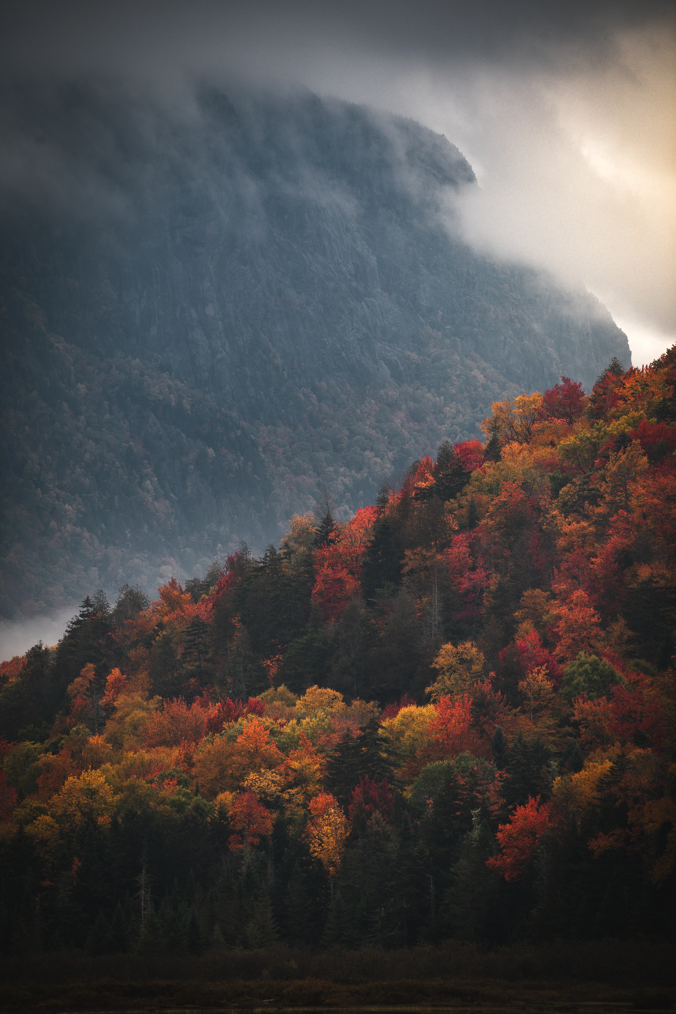 A telephoto view from Henderson Lake compresses Wallface and a nearer autumn ridge into two distinct layers. Henderson Lake, Adirondack High Peaks, New York.