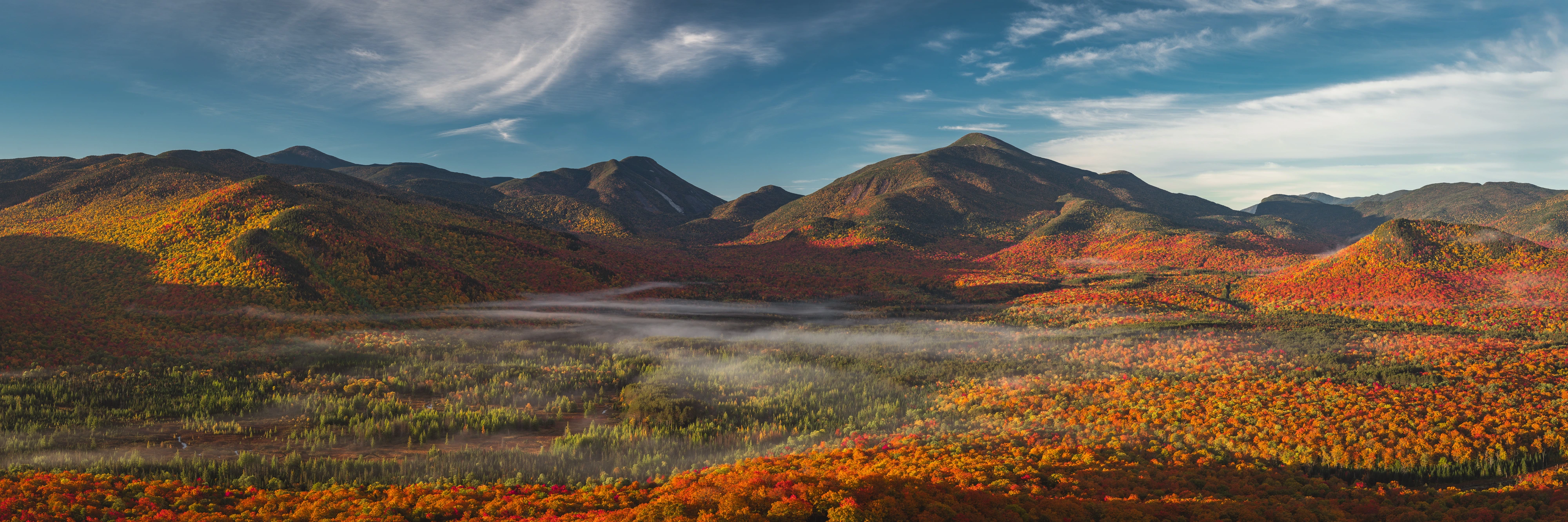 From Mount Van Hoevenberg, sunrise opens across the High Peaks while mist rests in South Meadow below. Mount Van Hoevenberg, Adirondack High Peaks, New York.