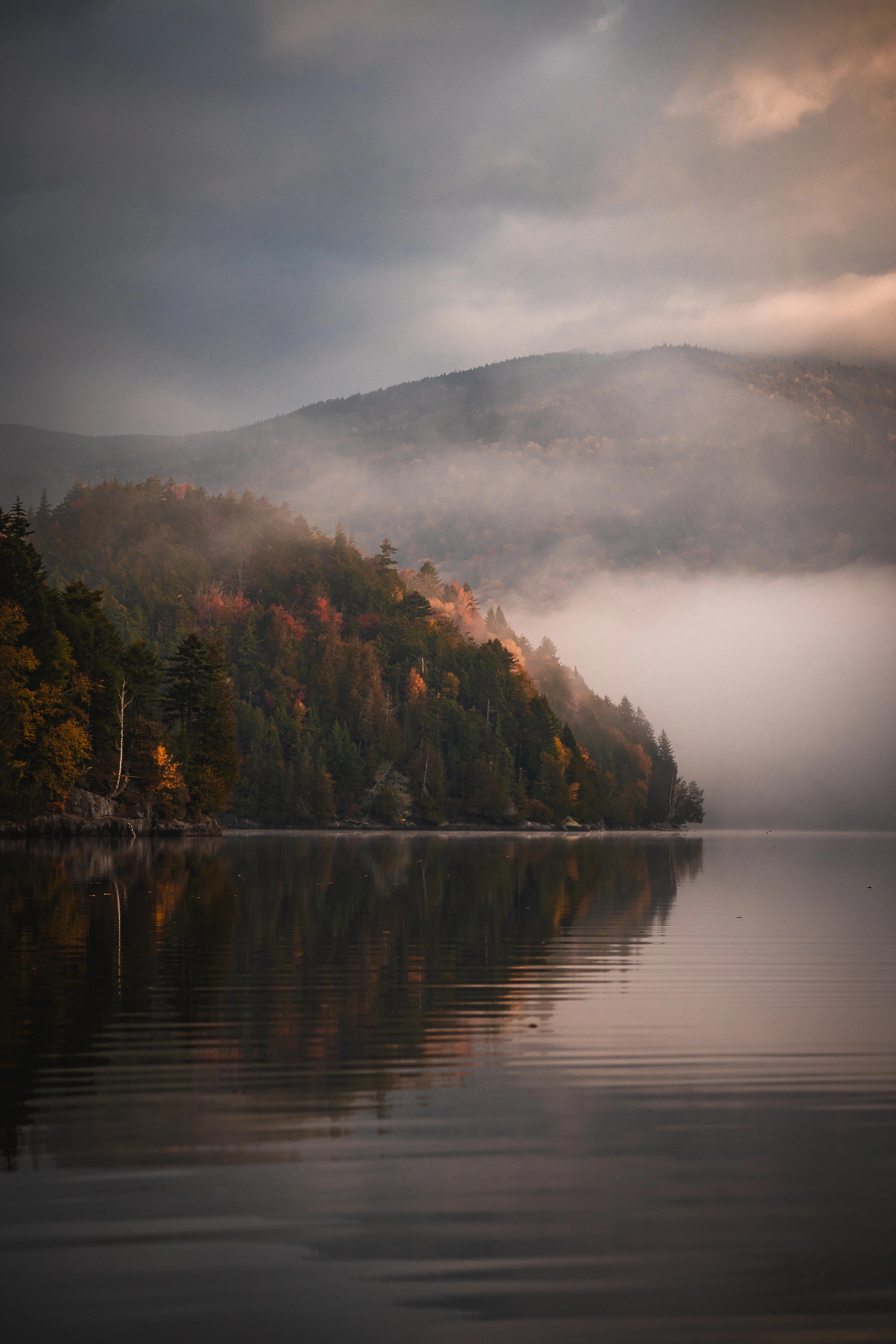 A wooded peninsula reaches into Henderson Lake beneath the lower slopes of McNaughton. Henderson Lake, Adirondack High Peaks, New York.